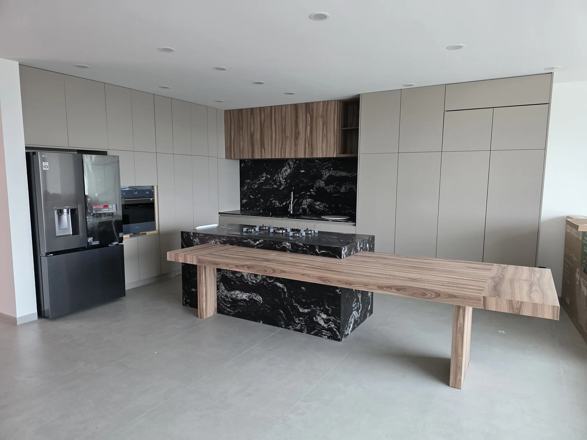 Cocina contemporánea con isla tipo mármol y mesa integrada realizado a medida por CarpyMobi