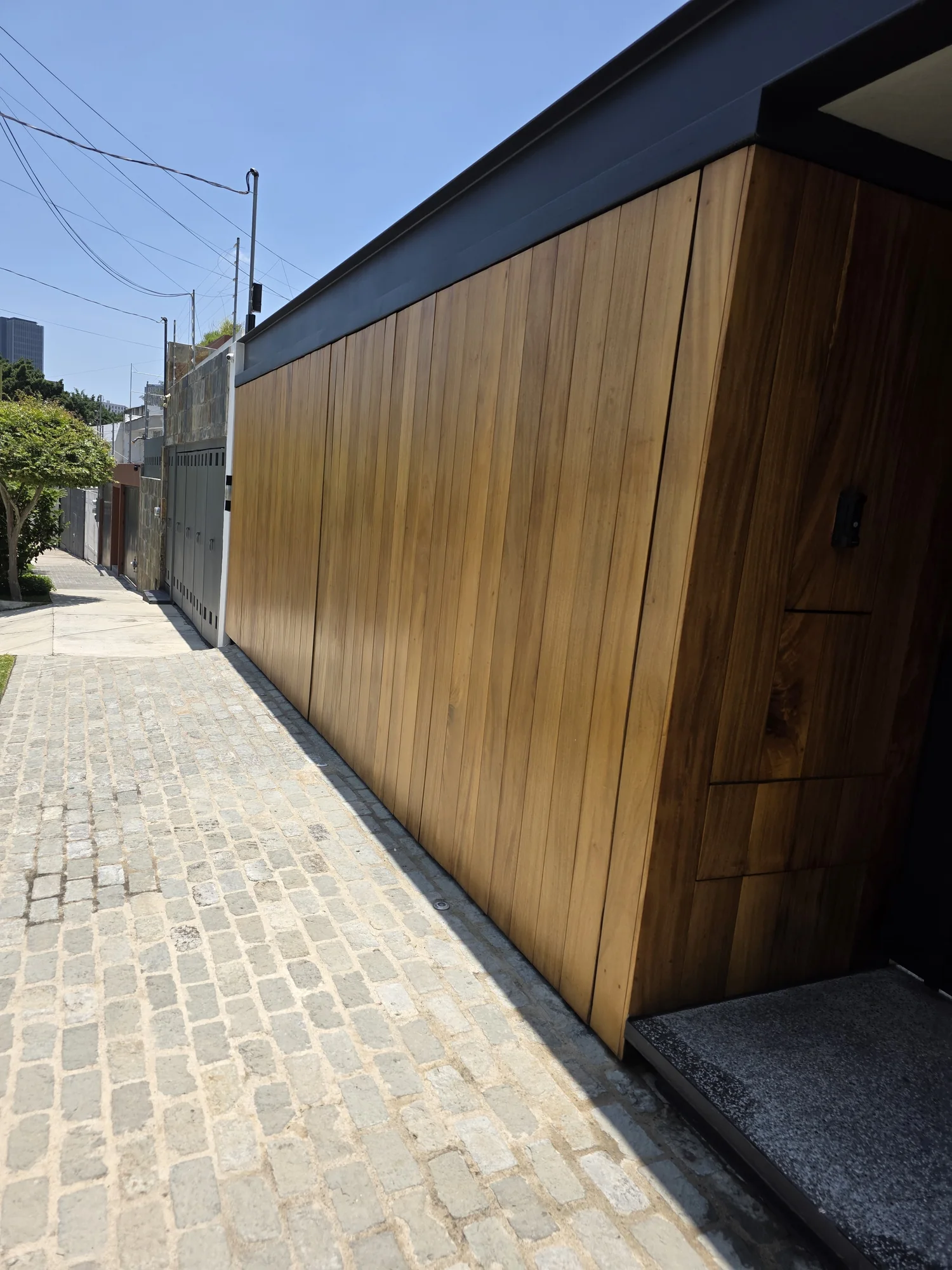 Fachada residencial revestida en madera desde perspectiva lateral realizado a medida por CarpyMobi