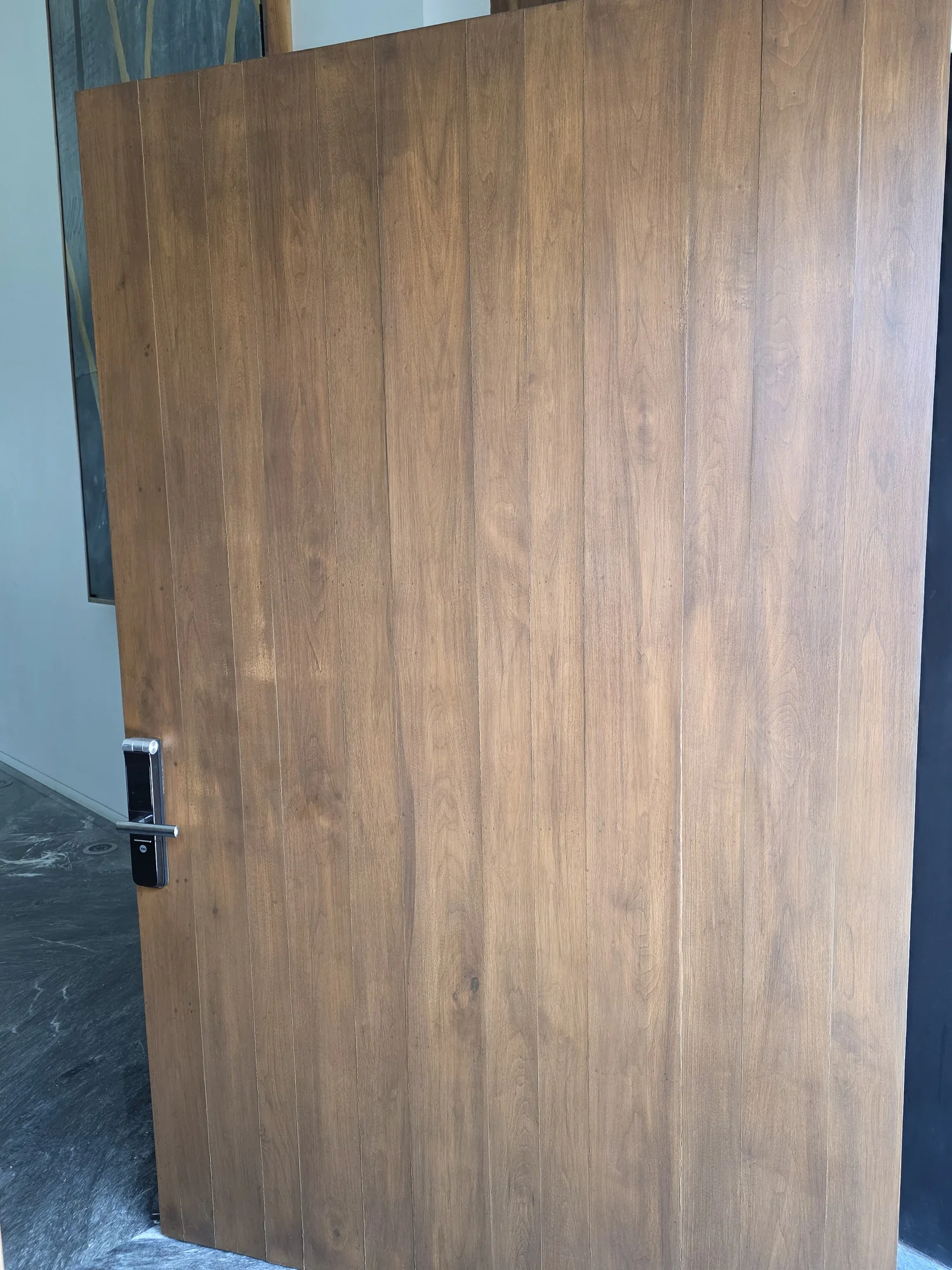 Detalle de puerta pivotante revestida en madera realizado a medida por CarpyMobi